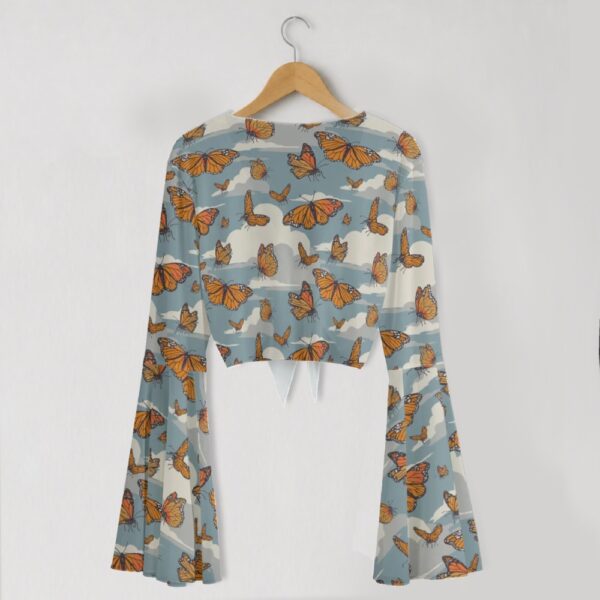 Monarch butterfly print mesh crop top with bell sleeves and tie front bow, all-over butterfly and cloud print on blue grey background, women's fit front view on hanger