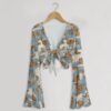 Monarch butterfly print mesh crop top with bell sleeves and tie front bow, all-over butterfly and cloud print on blue grey background, women's fit front view on hanger