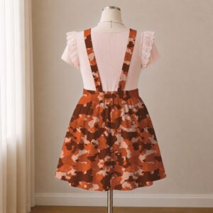 Orange and brown camo skirt overalls dress with adjustable straps and midi length skirt, all-over camouflage print