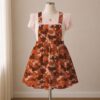 Orange and brown camo skirt overalls dress with adjustable straps and midi length skirt, all-over camouflage print