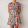 Strawberry Shortcake retro character print sundress worn by model, short sleeve flowy above knee fit with pink neckline trim