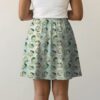 chikorita-skirt-bk Pokemon skater skirt with all-over print of Chikorita Pokemon with side pockets, worn by model