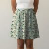 chikorita-skirt-fr Pokemon skater skirt with all-over print of Chikorita Pokemon with side pockets, worn by model