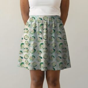 chikorita-skirt-fr Pokemon skater skirt with all-over print of Chikorita Pokemon with side pockets, worn by model