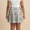 Studio Ghibli Spirited Away skater skirt with all-over print of Chihiro No Face Haku and Soot Sprites on rich teal background with side pockets worn by model