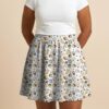 Studio Ghibli Spirited Away skater skirt with all-over print of Chihiro No Face Haku and Soot Sprites on rich teal background with side pockets worn by model